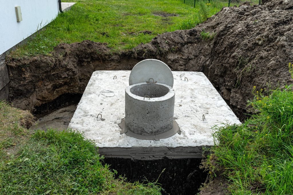 Concrete septic tank with a capacity of 10 cubic meters placed in the garden by the house.