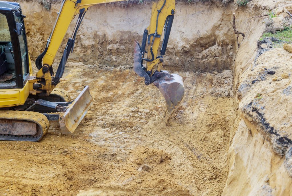 Best Excavating and Construction Contractor in Rutland Excavator during earthworks backhoe on work digs ground during earthworks for the foundation
